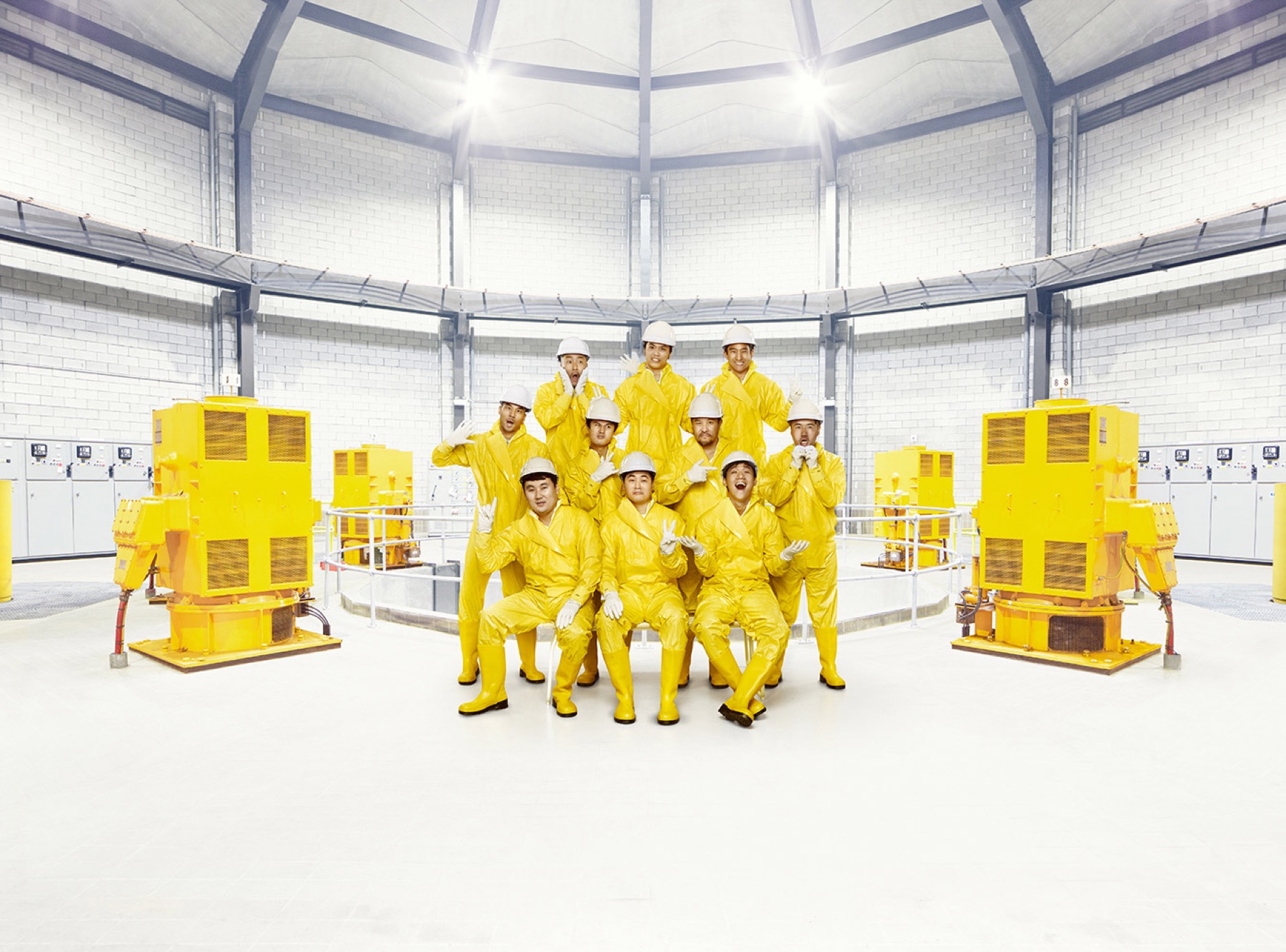 Group portrait in yellow protective clothing inside an industrial facility