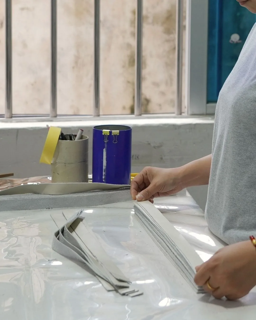 Hands cutting and preparing material strips for footwear production